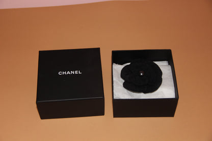 Broche Chanel camélia noire en tissu avec perle
