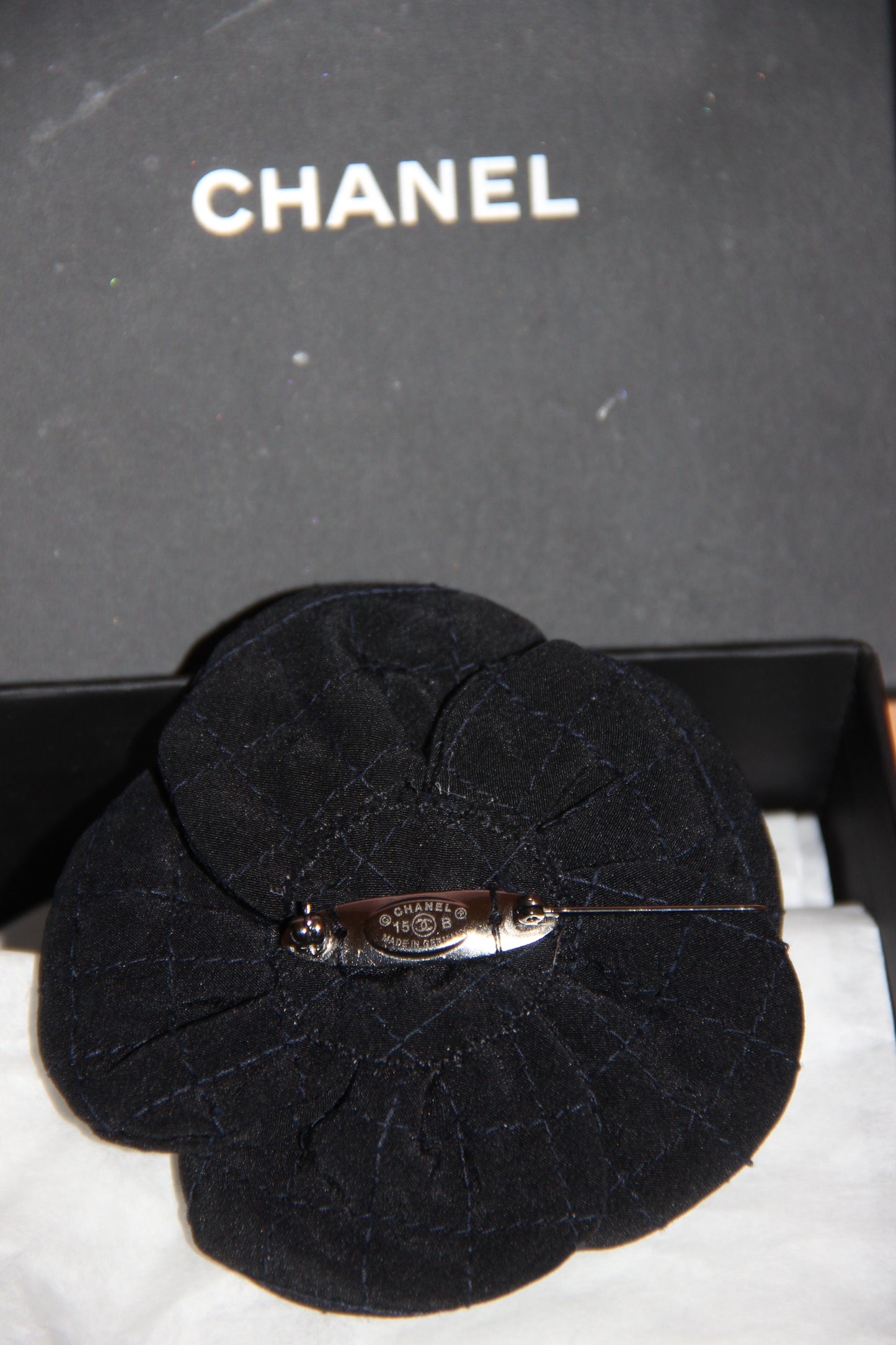 Broche Chanel camélia noire en tissu avec perle